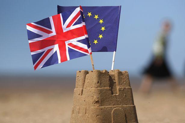 European-Union-and-the-Union-flag-sit-on-top-of-a-sand-castle